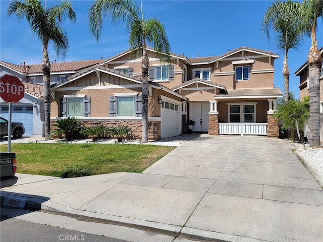 3052 Clapper St, Perris, CA 92571 - craftsman-style home featuring stucco siding, driveway, stone siding, a front yard, and a porch