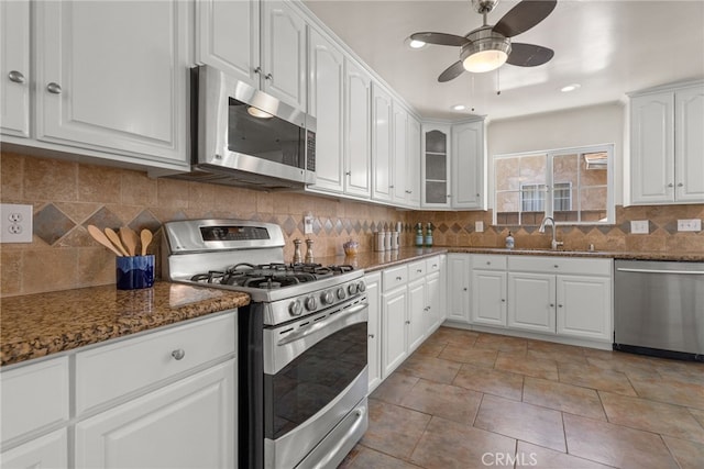 4033 N N Lang Ave, Covina, CA 91722 - kitchen featuring stainless steel appliances, a sink, dark stone countertops, a ceiling fan, and white cabinets