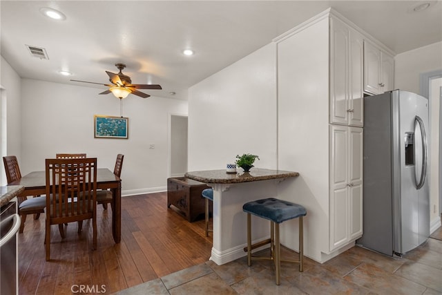 4033 N N Lang Ave, Covina, CA 91722 - kitchen featuring appliances with stainless steel finishes, a ceiling fan, white cabinetry, a kitchen bar, and baseboards