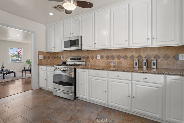 4033 N N Lang Ave, Covina, CA 91722 - kitchen with stainless steel appliances, white cabinets, a ceiling fan, decorative backsplash, and dark stone countertops
