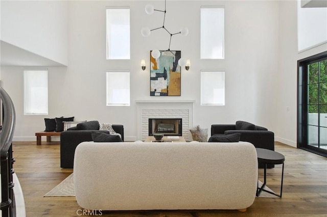 4322 Alcove Ave, Studio City, CA 91604 - living room featuring a towering ceiling, a fireplace, baseboards, and wood finished floors