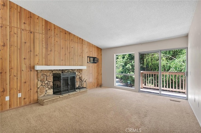 101 Rockledge Ln, Lake Arrowhead, CA 92352 - unfurnished living room with wooden walls, plenty of natural light, a textured ceiling, lofted ceiling, and carpet