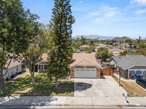 11191 Baker Ln, Riverside, CA 92505 - view of property hidden behind natural elements with concrete driveway, a garage, a mountain view, and a residential view