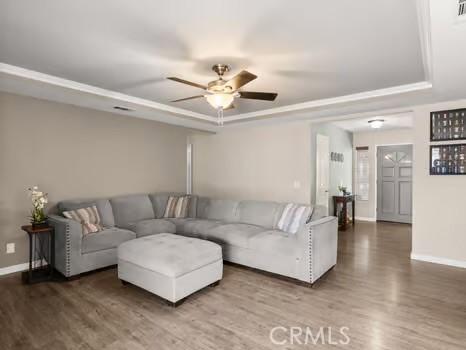 11191 Baker Ln, Riverside, CA 92505 - living room featuring a tray ceiling, wood finished floors, and baseboards