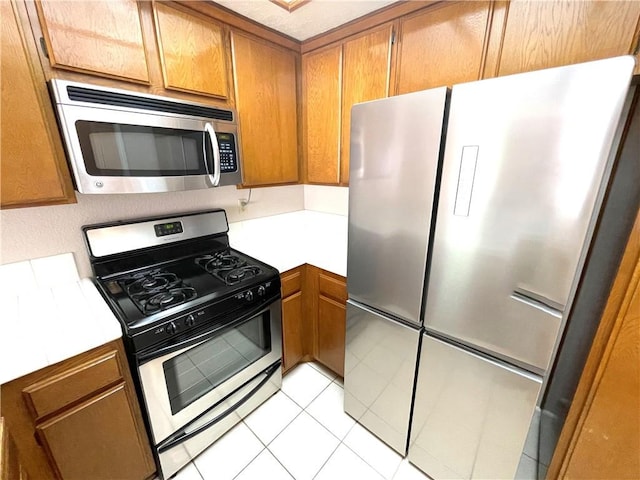 2563 Plaza Del Amo Unit 304, Torrance, CA 90503 - kitchen featuring appliances with stainless steel finishes, light countertops, and brown cabinetry