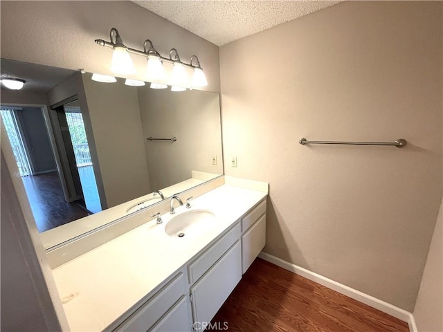 2563 Plaza Del Amo Unit 304, Torrance, CA 90503 - bathroom with wood finished floors, baseboards, a textured ceiling, and vanity