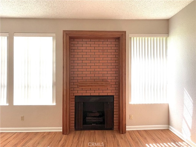 2563 Plaza Del Amo Unit 304, Torrance, CA 90503 - unfurnished living room featuring wood finished floors, a large fireplace, and a textured ceiling