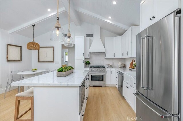 556 Through St, Laguna Beach, CA 92651 - kitchen with high end appliances, custom exhaust hood, light wood-style floors, a center island, and recessed lighting