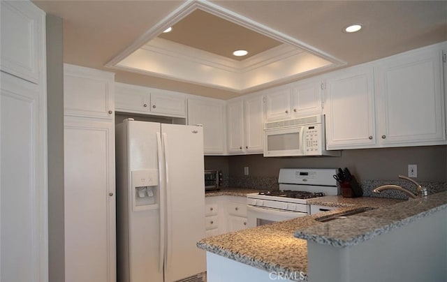 27971 Via Moreno, Laguna Niguel, CA 92677 - kitchen featuring white appliances, a tray ceiling, light stone countertops, recessed lighting, and white cabinetry