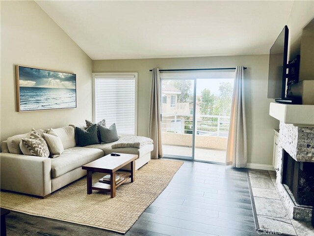 27971 Via Moreno, Laguna Niguel, CA 92677 - living area featuring wood finished floors, a stone fireplace, baseboards, and lofted ceiling