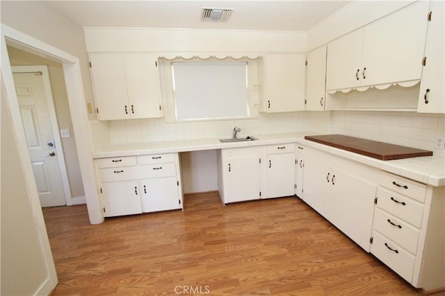 3641 Adams St, Riverside, CA 92504 - kitchen with a sink, backsplash, light wood finished floors, and white cabinets