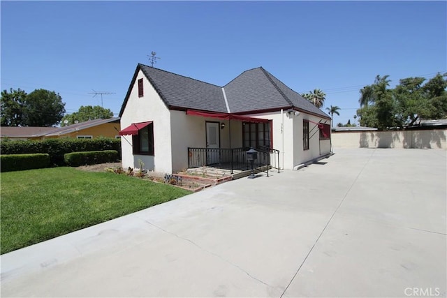 3641 Adams St, Riverside, CA 92504 - view of side of home with stucco siding, a lawn, and roof with shingles