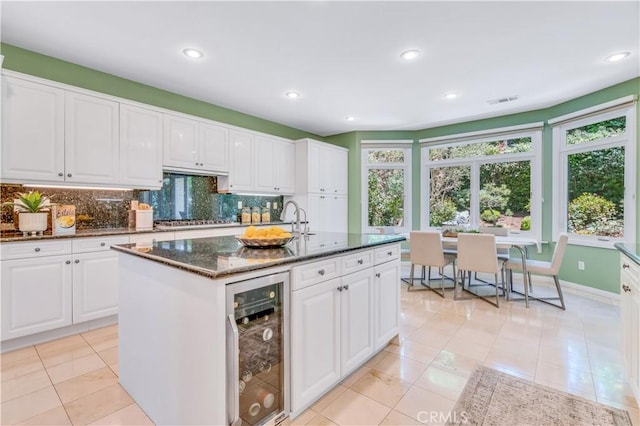 48 Via Porto Grande, Rancho Palos Verdes, CA 90275 - kitchen featuring wine cooler, tasteful backsplash, stainless steel gas stovetop, white cabinets, and dark stone countertops