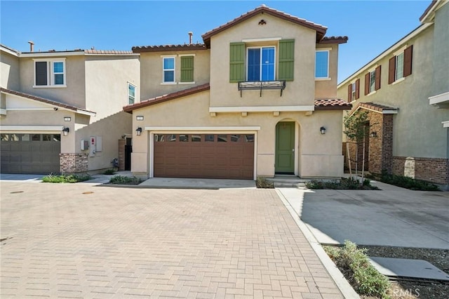 16233 Lozano St Unit 2, Fontana, CA 92336 - view of front of house with a tiled roof, stucco siding, a garage, and decorative driveway