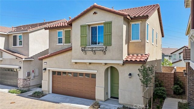16233 Lozano St Unit 2, Fontana, CA 92336 - view of front facade with a tile roof, an attached garage, stucco siding, and driveway