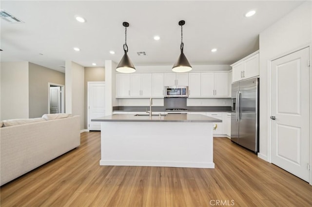 16233 Lozano St Unit 2, Fontana, CA 92336 - kitchen featuring stainless steel appliances, a sink, open floor plan, white cabinetry, and light wood-type flooring