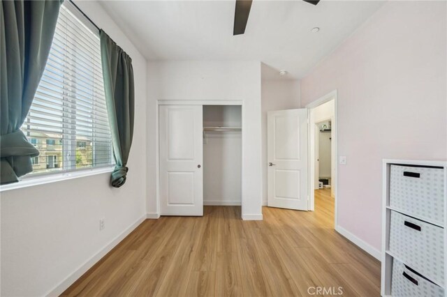 16233 Lozano St Unit 2, Fontana, CA 92336 - unfurnished bedroom featuring light wood-style floors, baseboards, a closet, and a ceiling fan