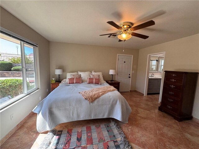 27568 Linda Vista Rd, Barstow, CA 92311 - tiled bedroom featuring baseboards, a sink, a ceiling fan, and connected bathroom