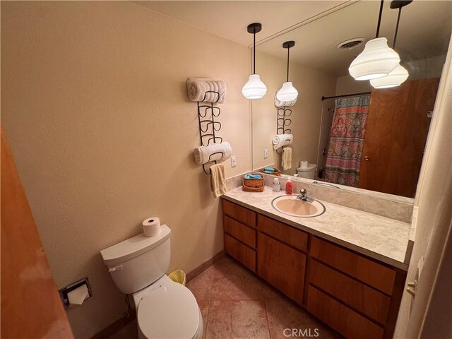 27568 Linda Vista Rd, Barstow, CA 92311 - full bath with toilet, vanity, tile patterned floors, baseboards, and a shower with curtain