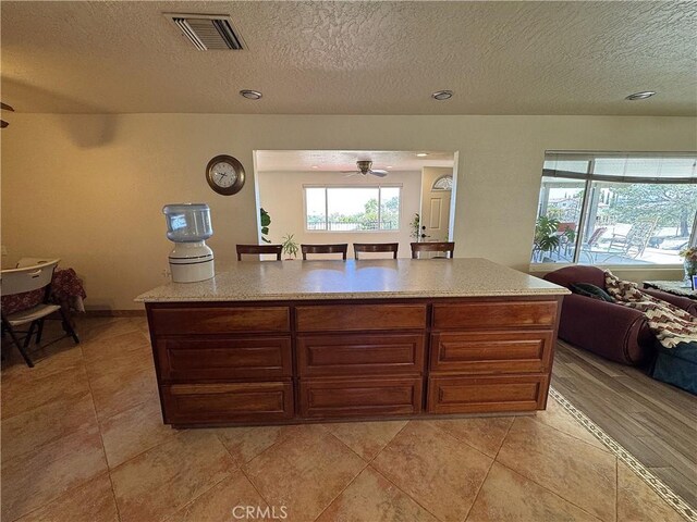 27568 Linda Vista Rd, Barstow, CA 92311 - kitchen with open floor plan, a textured ceiling, ceiling fan, and light tile patterned floors
