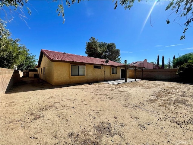 1305 Herzel Ave, Lancaster, CA 93535 - rear view of house with stucco siding, a patio, a fenced backyard, and a tiled roof