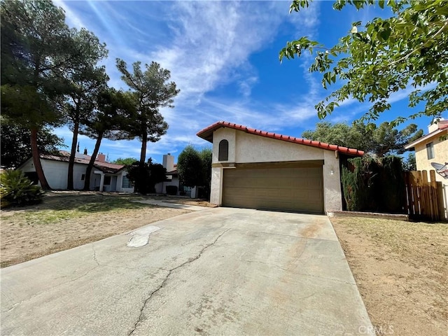 1305 Herzel Ave, Lancaster, CA 93535 - view of front of property with stucco siding, a tile roof, driveway, and a garage