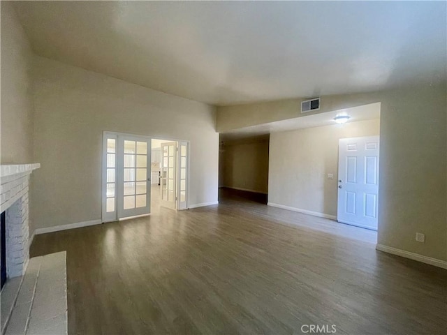 1305 Herzel Ave, Lancaster, CA 93535 - unfurnished living room with wood finished floors, a brick fireplace, and baseboards