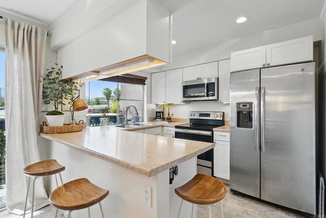 7930 Mission Center Ct Unit F, San Diego, CA 92108 - kitchen with stainless steel appliances, a sink, a peninsula, a kitchen breakfast bar, and light countertops