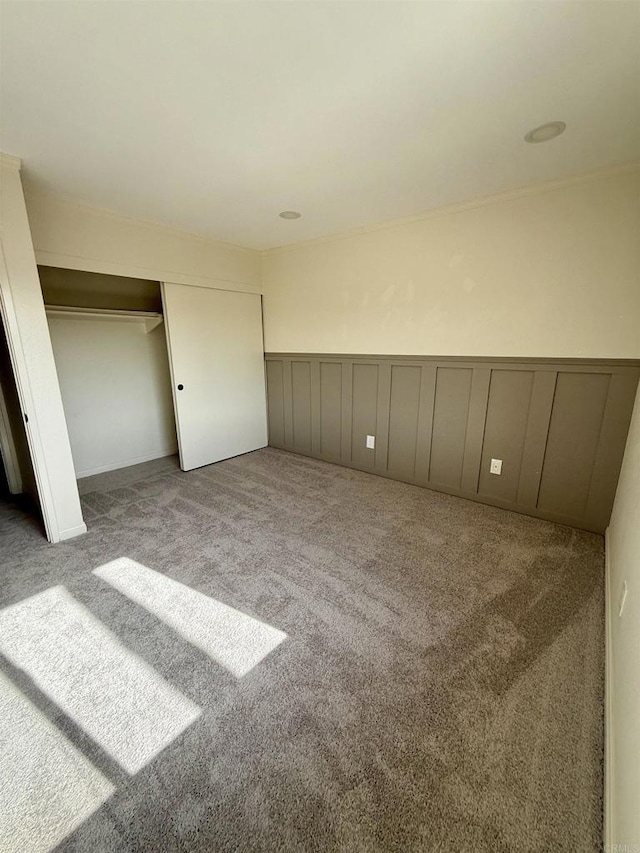 7930 Mission Center Ct Unit F, San Diego, CA 92108 - unfurnished bedroom with carpet, wainscoting, a decorative wall, and a closet