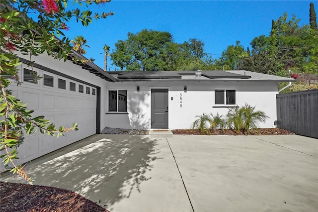5548 Irondale Ave, Los Angeles, CA 91367 - view of front of home featuring stucco siding, solar panels, a garage, and driveway