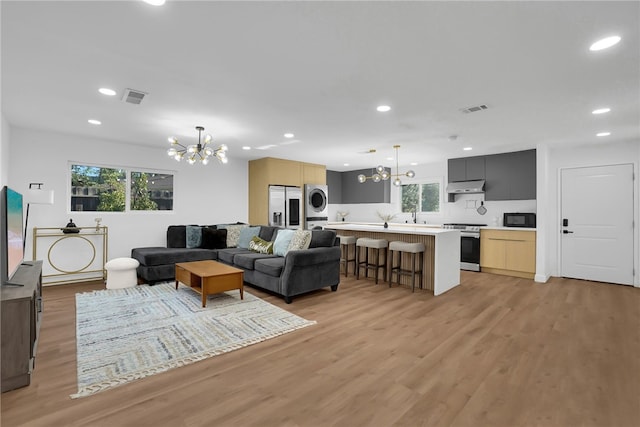 5548 Irondale Ave, Los Angeles, CA 91367 - living room with a chandelier, light wood-style flooring, recessed lighting, and estacked washer and dryer