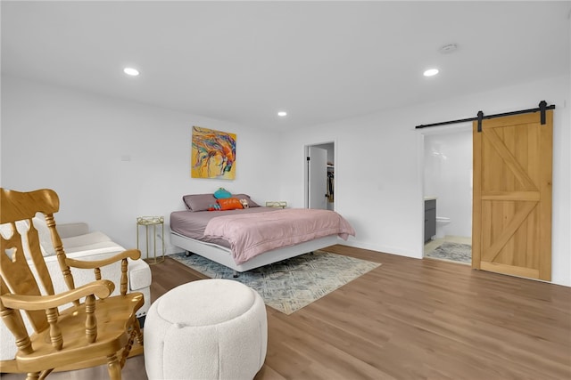 5548 Irondale Ave, Los Angeles, CA 91367 - bedroom with a barn door, wood finished floors, recessed lighting, a walk in closet, and ensuite bathroom