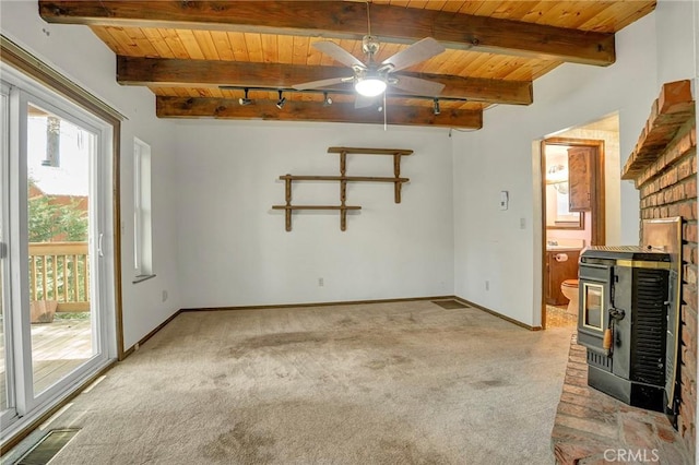 33079 Ridge Rd, Arrowbear, CA 92382 - spare room featuring wood ceiling with exposed beams, light carpet, a wood stove, a ceiling fan, and baseboards