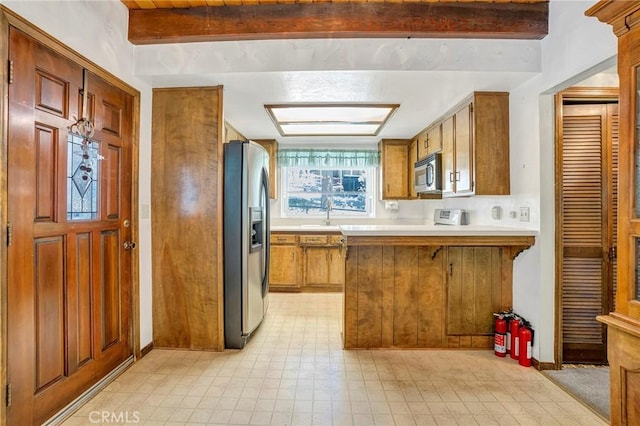 33079 Ridge Rd, Arrowbear, CA 92382 - kitchen with stainless steel appliances, beam ceiling, a peninsula, light flooring, and light countertops