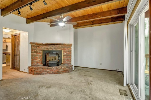 33079 Ridge Rd, Arrowbear, CA 92382 - unfurnished living room with a wood stove, wood ceiling with exposed beams, carpet, a ceiling fan, and baseboards