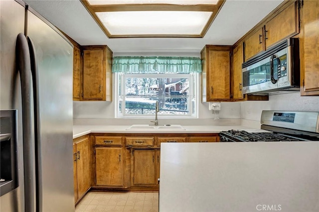 33079 Ridge Rd, Arrowbear, CA 92382 - kitchen featuring appliances with stainless steel finishes, a sink, brown cabinets, light countertops, and light floors