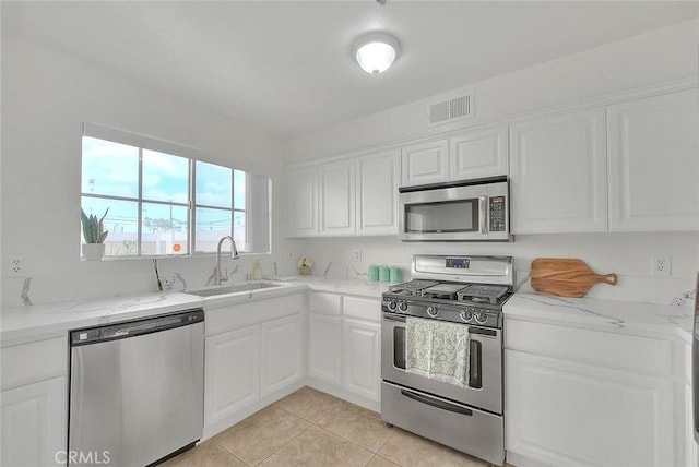 4315 W 145th St Unit 10, Lawndale, CA 90260 - kitchen with stainless steel appliances, a sink, white cabinets, light tile patterned floors, and light stone countertops