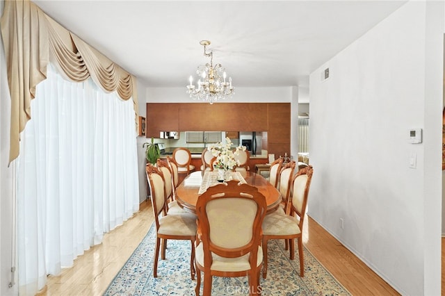 11952 Darlington Ave Unit 6, Los Angeles, CA 90049 - dining space with a chandelier and light wood-style flooring