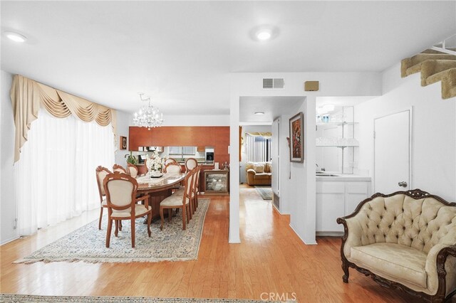 11952 Darlington Ave Unit 6, Los Angeles, CA 90049 - dining space with a chandelier and light wood-type flooring