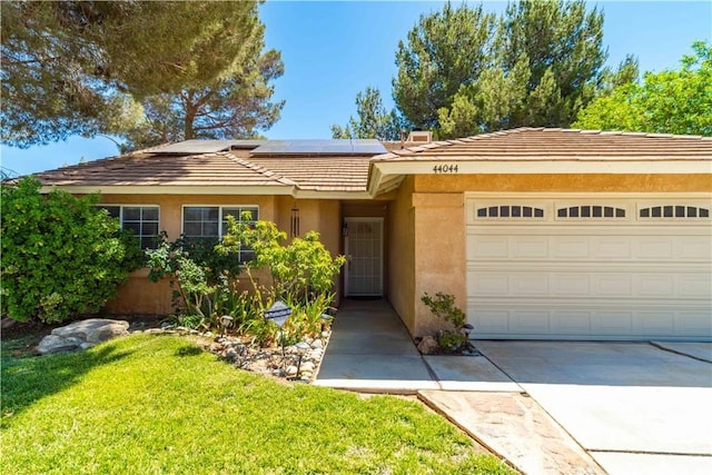 44044 11th St E, Lancaster, CA 93535 - view of front of home featuring stucco siding, roof mounted solar panels, an attached garage, driveway, and a tile roof