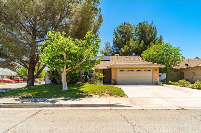 44044 11th St E, Lancaster, CA 93535 - view of front of home featuring a garage, a tiled roof, roof mounted solar panels, driveway, and stucco siding