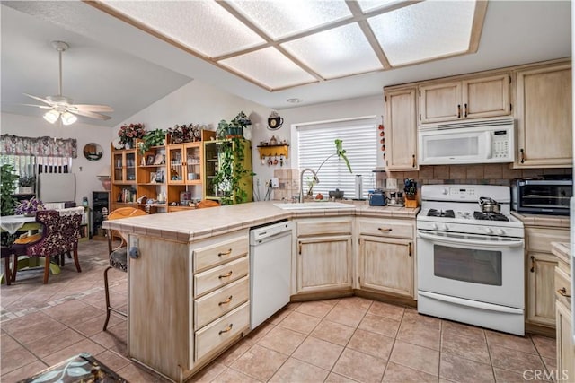 44044 11th St E, Lancaster, CA 93535 - kitchen with white appliances, a sink, tile counters, a peninsula, and lofted ceiling