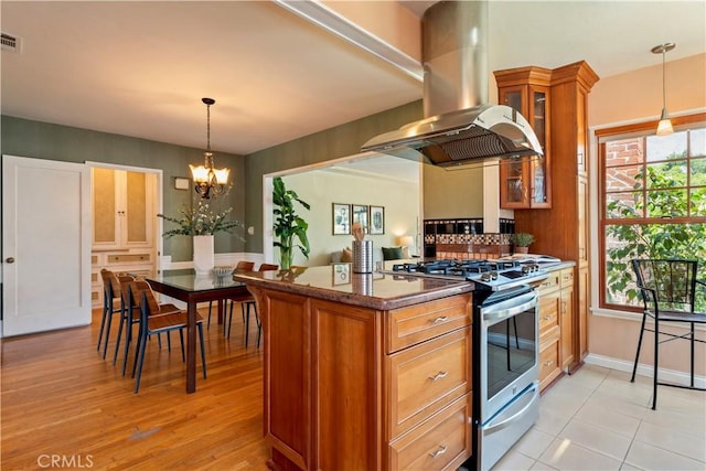 2042 E Crary St, Pasadena, CA 91104 - kitchen with island range hood, stainless steel gas stove, brown cabinets, glass insert cabinets, and a chandelier