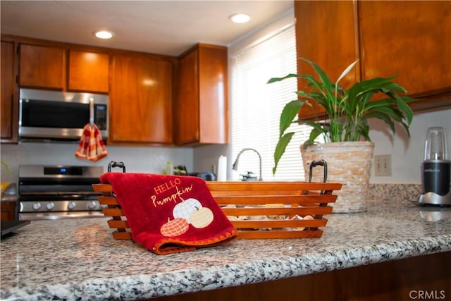 916 E 65th St Unit 3, Inglewood, CA 90302 - kitchen featuring appliances with stainless steel finishes, brown cabinets, light stone countertops, and recessed lighting