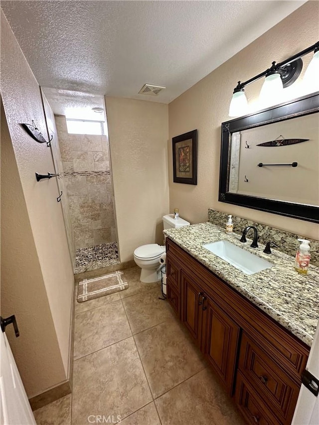 915 Beach Dr, Needles, CA 92363 - full bathroom featuring a textured ceiling, toilet, vanity, walk in shower, and tile patterned flooring