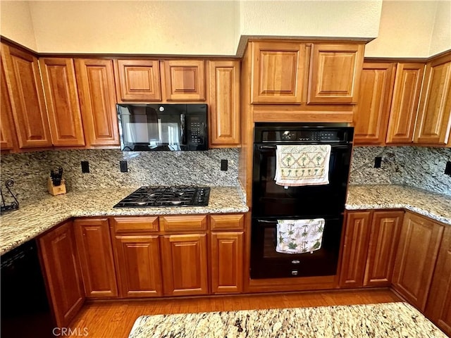 915 Beach Dr, Needles, CA 92363 - kitchen with black appliances, brown cabinets, and light wood-style flooring