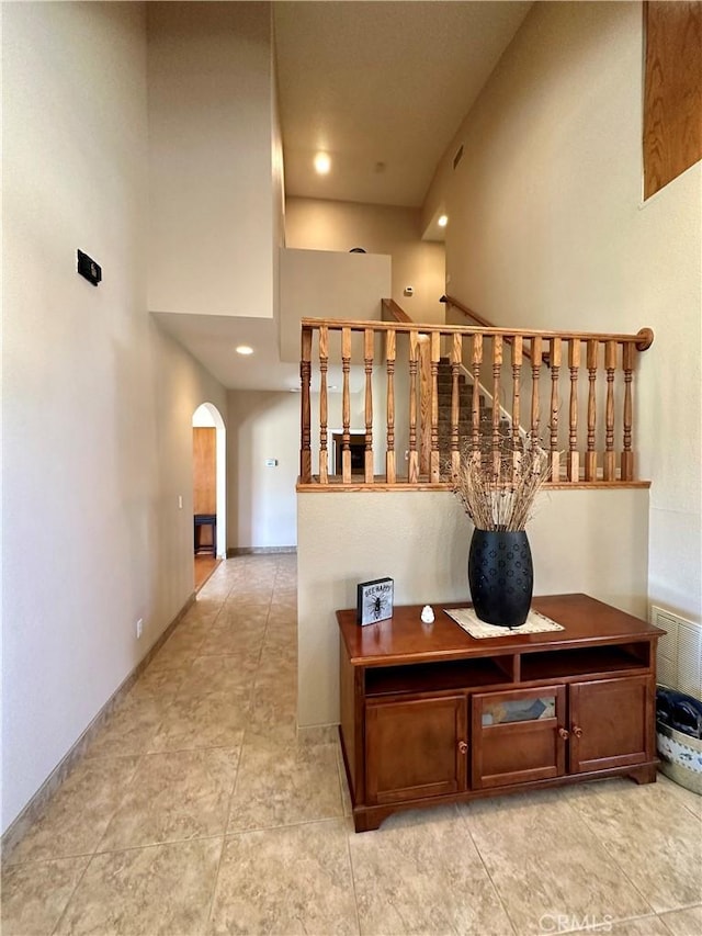 915 Beach Dr, Needles, CA 92363 - stairs featuring arched walkways, a high ceiling, recessed lighting, and tile patterned flooring