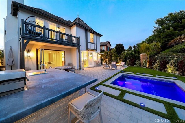 32 Bargemon, Newport Coast, CA 92657 - rear view of house with a balcony, a patio, stucco siding, an outdoor pool, and a hot tub
