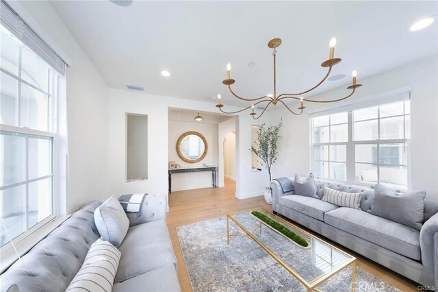 32 Bargemon, Newport Coast, CA 92657 - living area with a chandelier, plenty of natural light, light wood-style floors, recessed lighting, and arched walkways