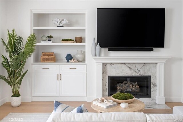 32 Bargemon, Newport Coast, CA 92657 - living room featuring light wood-style flooring, a fireplace, and built in shelves